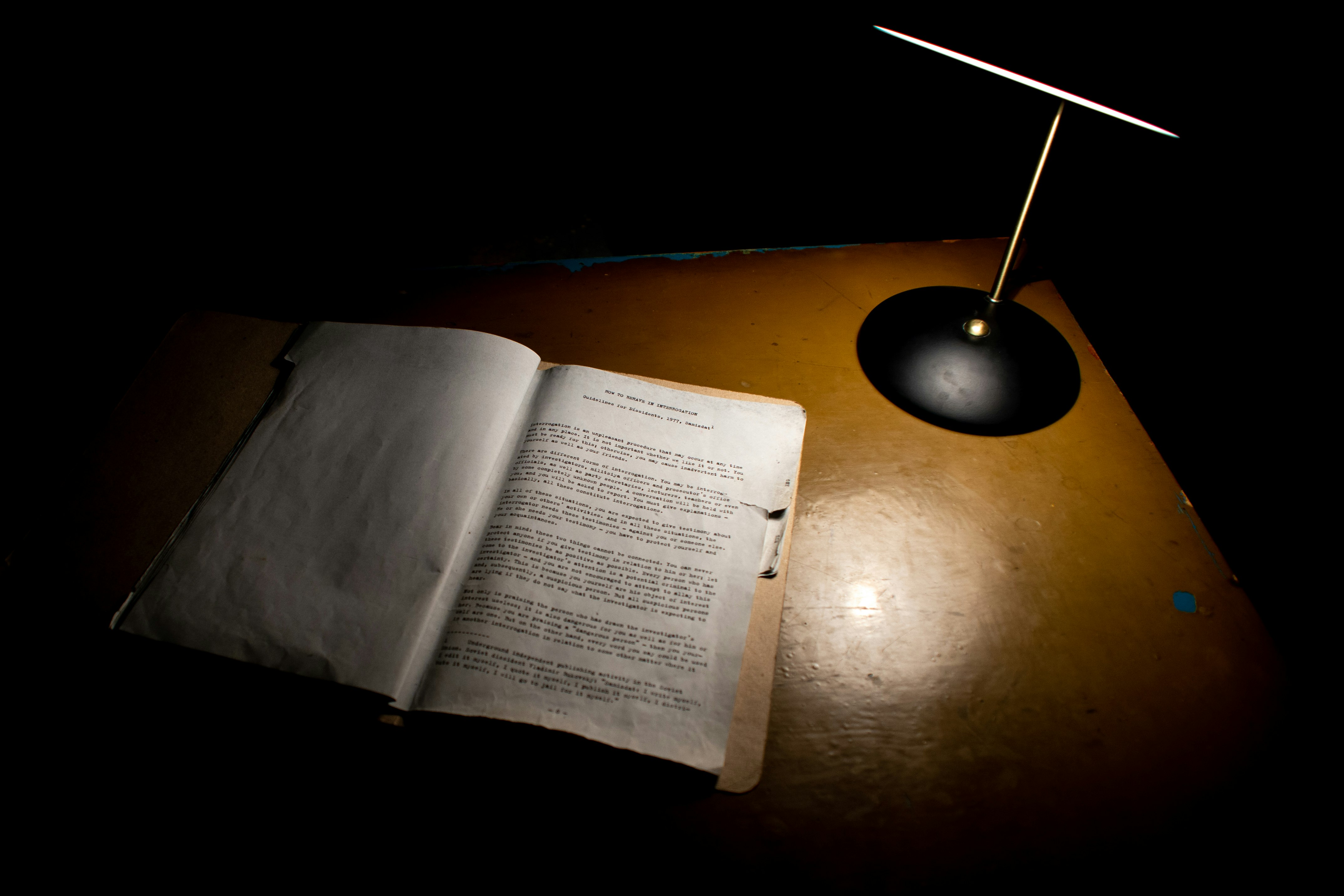 open book beside black table lamp